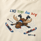 Close-up of an ivory white t-shirt showing a crashed moose lying upside down in the snow with loose ski gear and colorful “Are My Skis OK?” text.