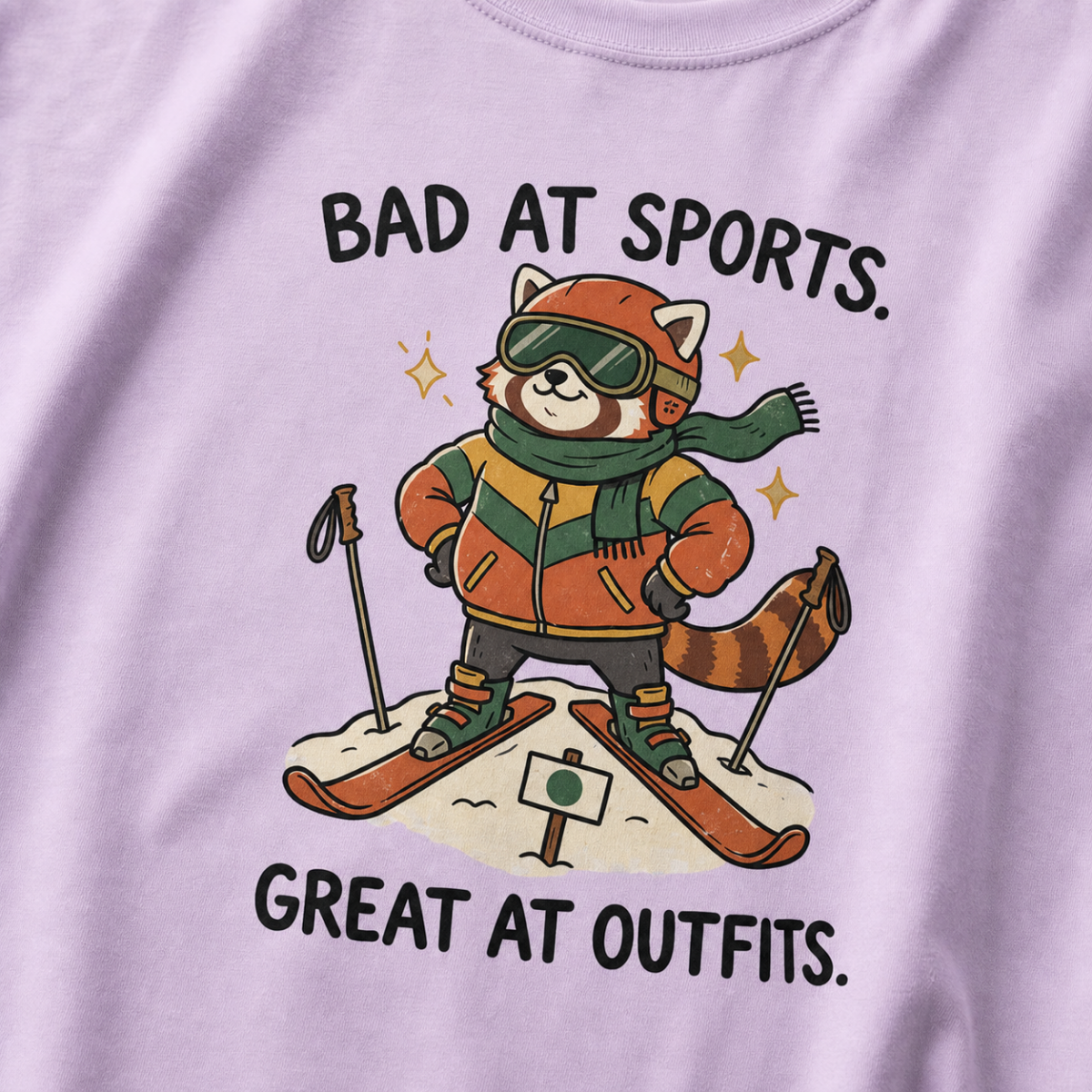 Close-up of an orchid t-shirt featuring a stylish red panda skier posing in coordinated winter gear with “Bad at Sports. Great at Outfits.” text.