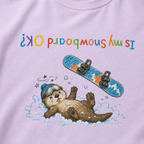 Close-up of an orchid t-shirt showing a crashed otter in ski goggles with a snowboard flying overhead and colourful upside-down “Is My Snowboard OK?” text.