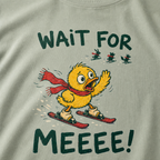 Close-up of a bay green t-shirt showing a worried duck skier calling after three distant animals, with bold “Wait for Meeee!” text.
