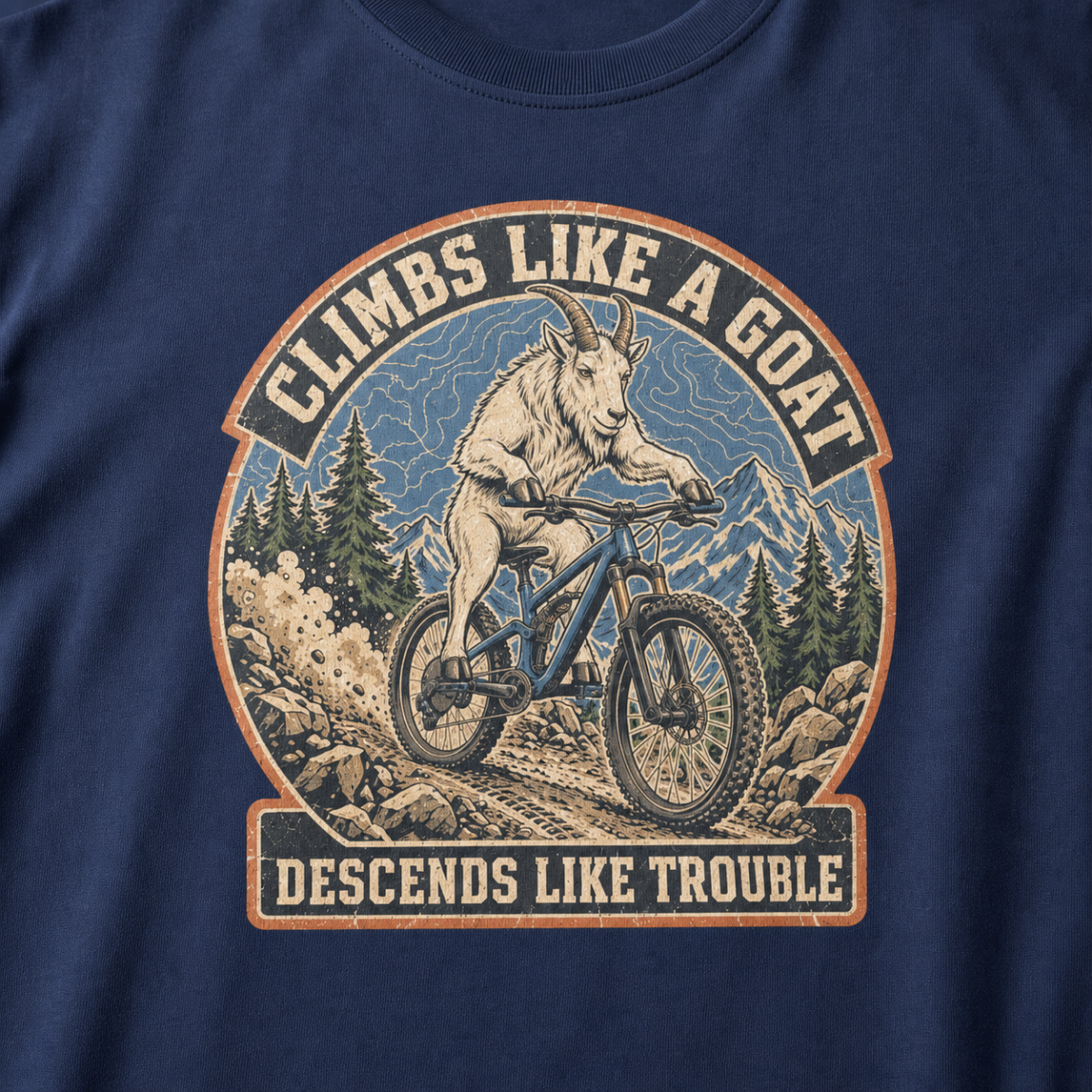 Close-up of a distressed mountain biking design featuring a goat descending a rocky trail with alpine peaks and “Climbs Like a Goat, Descends Like Trouble” lettering.