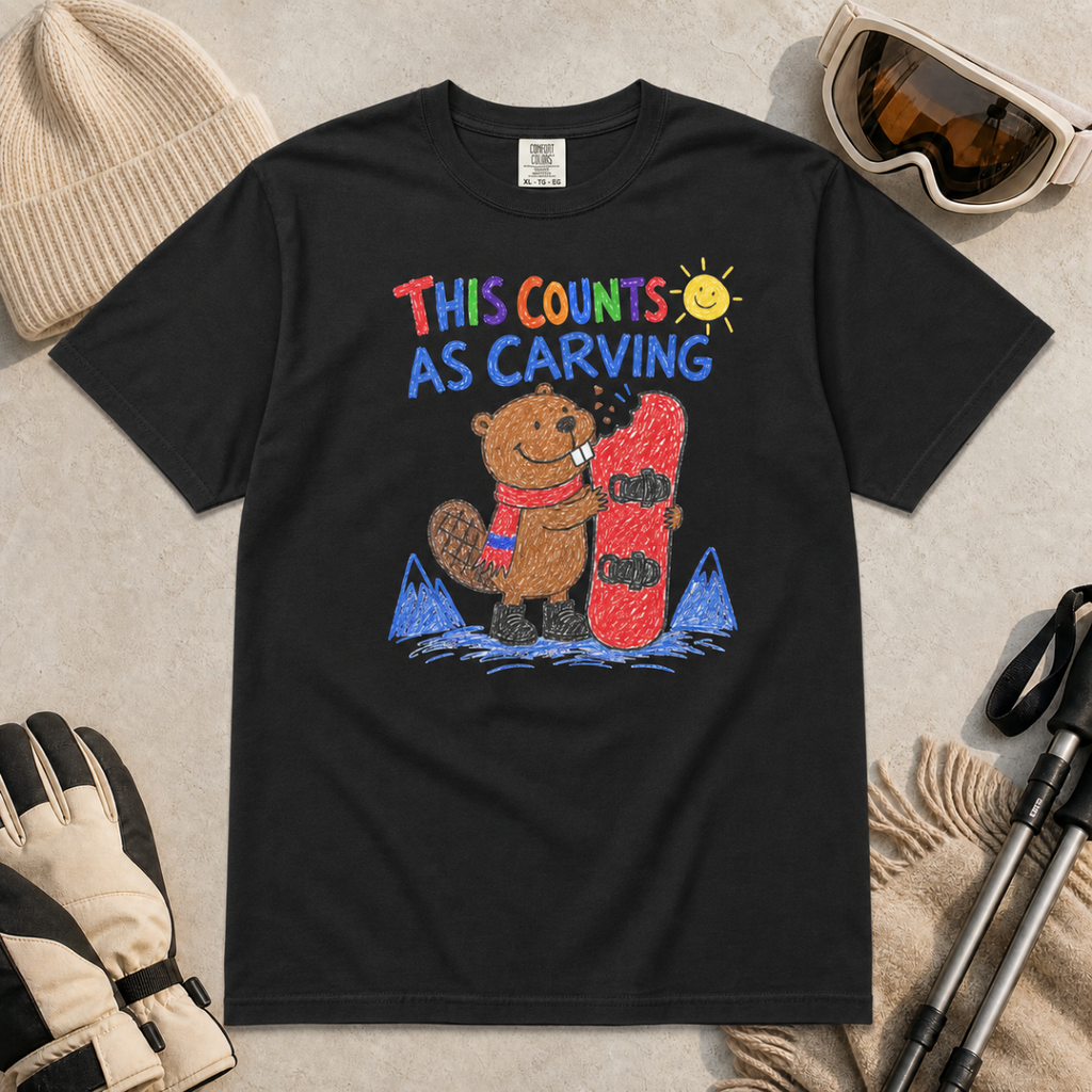 Flat lay of a black t-shirt with a playful beaver snowboarding design showing the animal chewing a board beneath “This Counts as Carving” text.