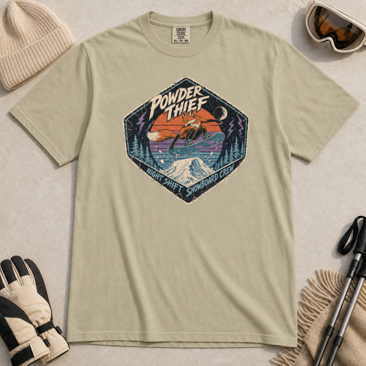 Khaki t-shirt featuring a distressed retro fox snowboarder jumping over a snowy mountain beneath “Powder Thief” lettering.