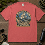 Crimson red t-shirt featuring a vintage mountain goat riding a mountain bike through rocky alpine terrain with “Climbs Like a Goat, Descends Like Trouble” text.