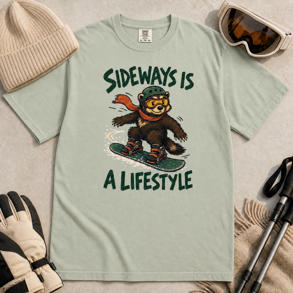 Flat lay of a bay green t-shirt with a playful wolverine snowboard graphic and bold “Sideways Is a Lifestyle” text.