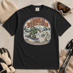 Black t-shirt featuring a vintage backcountry badge design with Bigfoot snowboarding, a mountain bike, snowy peaks, and “I Packed for Everything” lettering.
