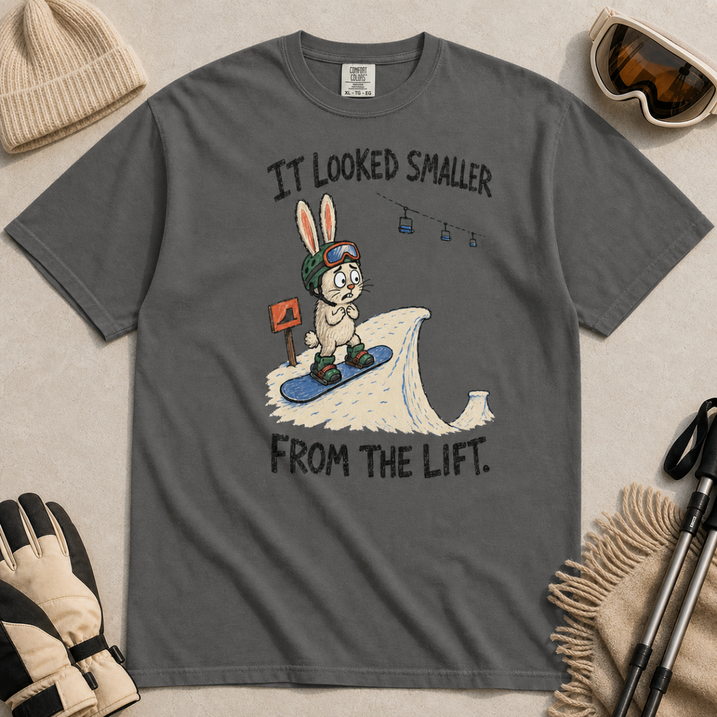 Flat lay of a pepper gray t-shirt with a humorous snowboarding design showing a worried rabbit facing an unexpectedly steep jump.