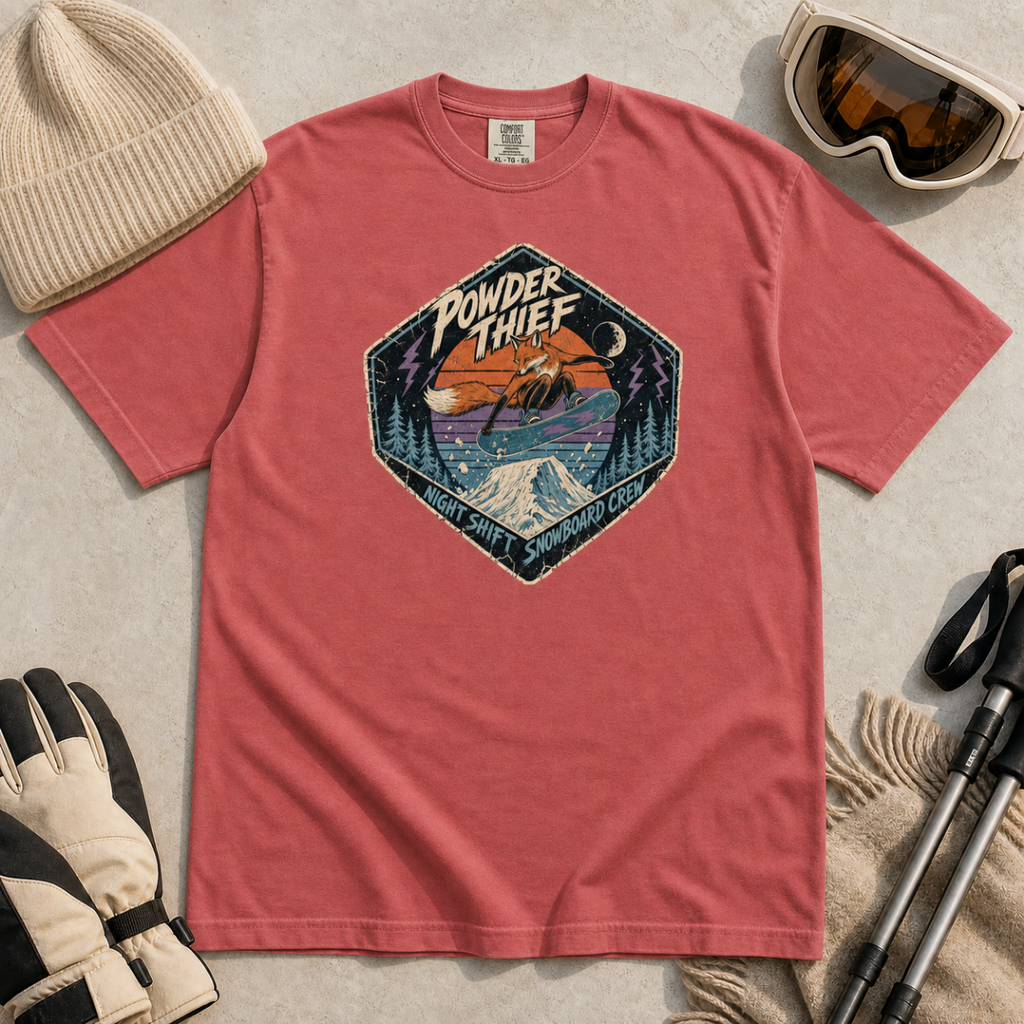 Crimson red t-shirt featuring a distressed retro fox snowboarder jumping over a snowy mountain beneath “Powder Thief” lettering.