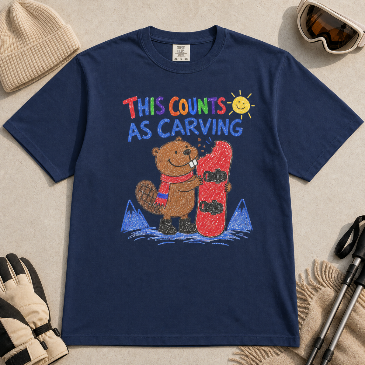 Flat lay of a navy t-shirt with a playful beaver snowboarding design showing the animal chewing a board beneath “This Counts as Carving” text.