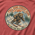 Close-up of a distressed vintage-style bear skiing through snowy mountains with “Full Send Forest Club” and “Ski the Wild Side” lettering.