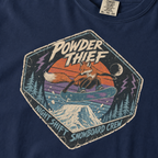 Close-up of a navy blue t-shirt featuring a vintage fox snowboarding at night with “Powder Thief – Night Shift Snowboard Crew” text.