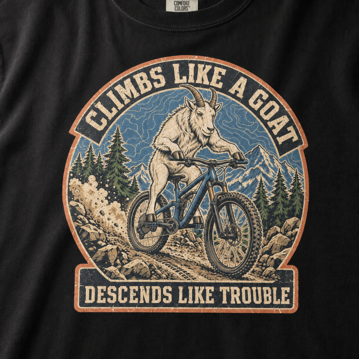 Close-up of a distressed mountain biking design featuring a goat descending a rocky trail with alpine peaks and “Climbs Like a Goat, Descends Like Trouble” lettering.