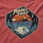 Close-up of a crimson red t-shirt featuring a vintage fox snowboarding at night with “Powder Thief – Night Shift Snowboard Crew” text.