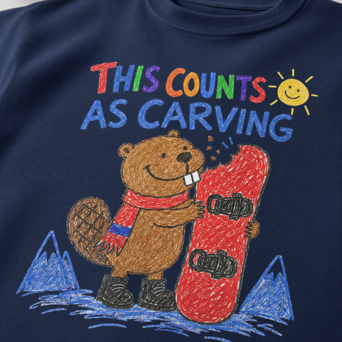 Close-up of a navy t-shirt featuring a childlike crayon-style beaver biting a red snowboard, with colourful “This Counts as Carving” text.