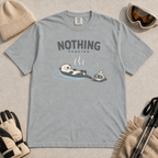 Granite gray t-shirt featuring a relaxed otter floating in a hot spring beside winter goggles and a beanie, with the words “Nothing Pending.”