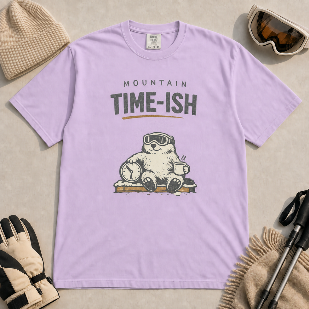 Orchid purple t-shirt featuring a relaxed marmot in ski goggles holding a clock and steaming mug beneath the words “Mountain Time-ish.”