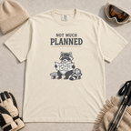 Ivory white t-shirt featuring a raccoon in ski goggles sitting on a bench and studying a trail map, with the words “Not Much Planned.”