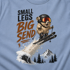 Close-up of a pika performing an airborne ski jump above snowy mountains and trees with the phrase “Small Legs Big Send.”