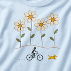 Close-up of a female mountain biker riding beside a yellow dog beneath four large hand-drawn daisies.