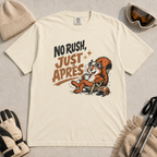 Ivory white t-shirt featuring a relaxed red squirrel in ski goggles sitting in a chair with a steaming mug and ski helmet, beside the words “No Rush, Just Après.”