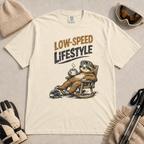 Ivory white t-shirt featuring a relaxed sloth in ski goggles rocking in a chair with a hot drink beneath the words “Low-Speed Lifestyle.”