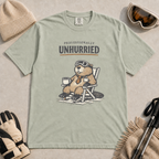 Bay green  t-shirt featuring a relaxed beaver in ski goggles and a necktie, seated with a mug beneath “Professionally Unhurried” lettering.