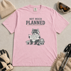 Blossom pink t-shirt featuring a raccoon in ski goggles sitting on a bench and studying a trail map, with the words “Not Much Planned.”