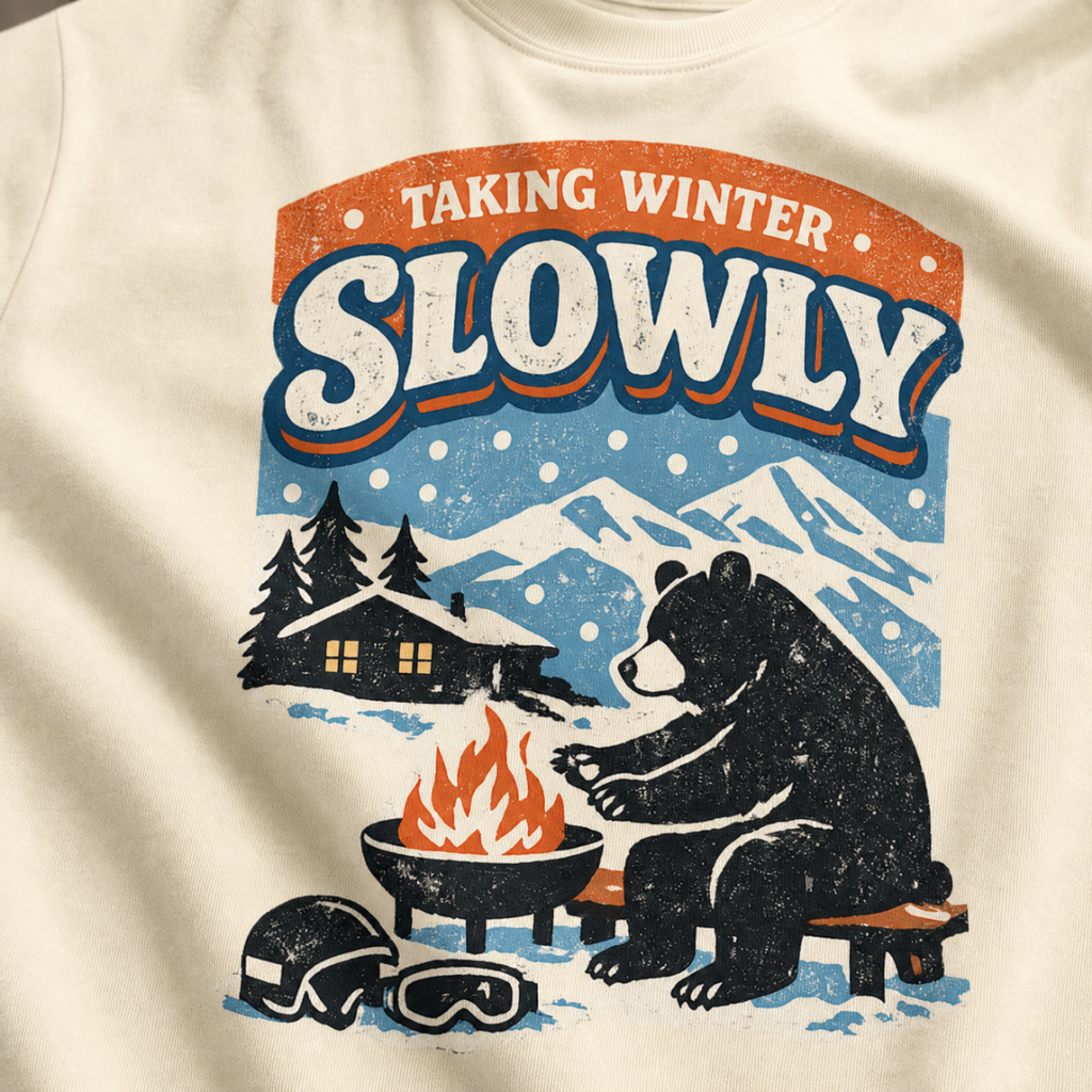 Close-up of a bear sitting beside a winter fire with snowy mountains, a cabin, helmet and goggles.