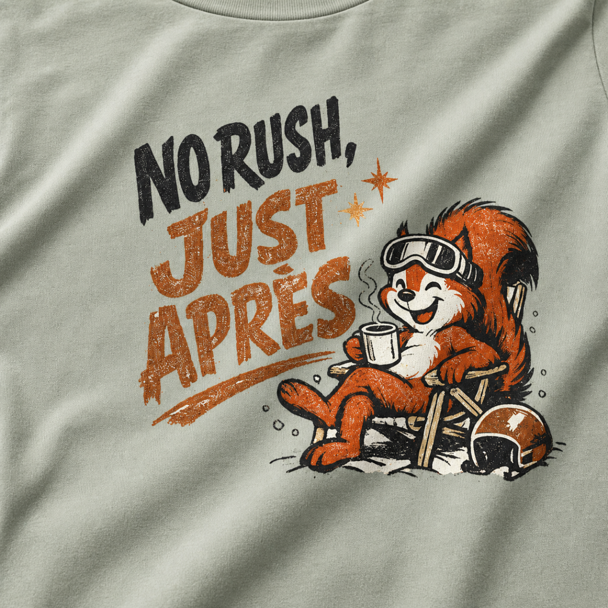 Close-up of a bay green t-shirt featuring a relaxed red squirrel in ski goggles reclining in a chair with a steaming mug, beside the words “No Rush, Just Après.”