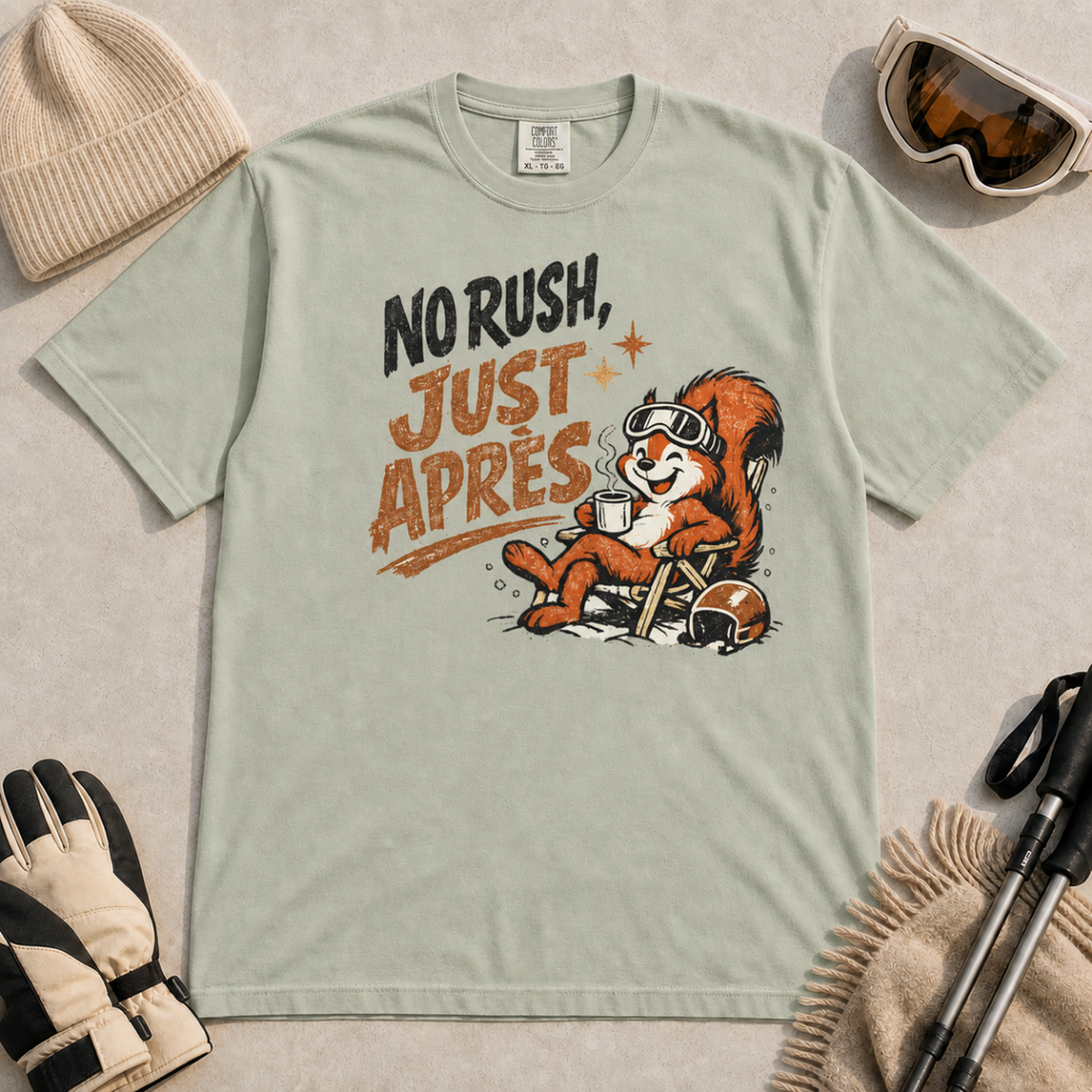 Bay green t-shirt featuring a relaxed red squirrel in ski goggles sitting in a chair with a steaming mug and ski helmet, beside the words “No Rush, Just Après.”