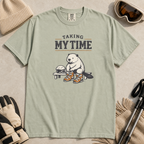 Bay green t-shirt featuring a beaver seated on a bench fastening snowboard boots beneath “Taking My Time” text.