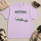 Orchid purple t-shirt featuring a relaxed otter floating in a hot spring beside winter goggles and a beanie, with the words “Nothing Pending.”