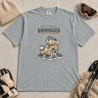 Granite grey t-shirt featuring a relaxed beaver in ski goggles and a necktie, seated with a mug beneath “Professionally Unhurried” lettering.
