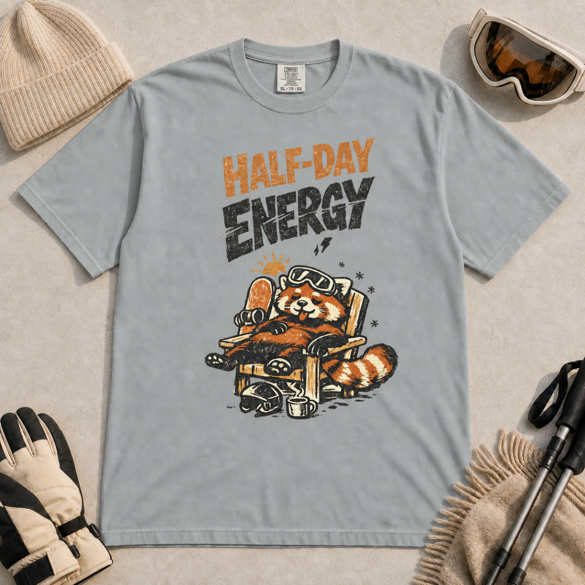 Granite gray t-shirt featuring a relaxed red panda in a chair beside a helmet and mug with the phrase “Half-Day Energy.”