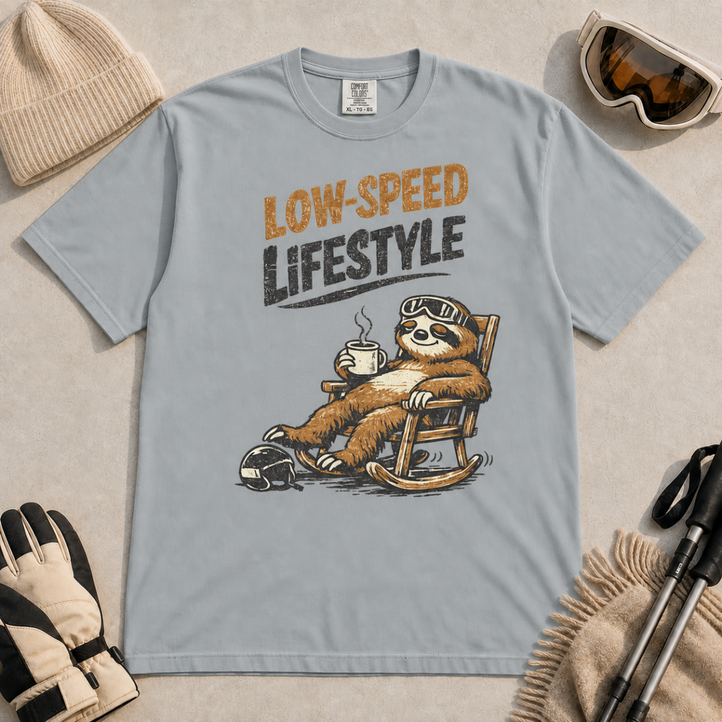 Granite gray t-shirt featuring a relaxed sloth in ski goggles rocking in a chair with a hot drink beneath the words “Low-Speed Lifestyle.”