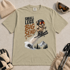 Khaki t-shirt featuring a helmeted pika launching off a snowy ski jump with the phrase “Small Legs Big Send.”