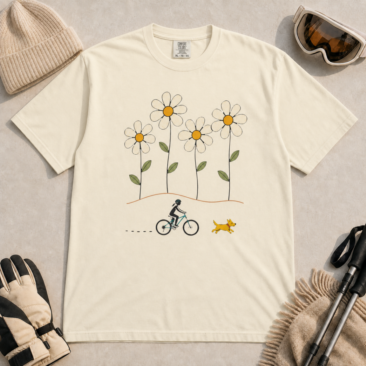 Ivory white t-shirt featuring a small female mountain biker and yellow dog beneath four oversized daisies.