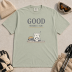 Bay green t-shirt featuring a small white bear holding a mug beside ski goggles with the phrase “Good Where I Am.”