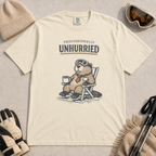 Ivory white t-shirt featuring a relaxed beaver in ski goggles and a necktie, seated with a mug beneath “Professionally Unhurried” lettering.