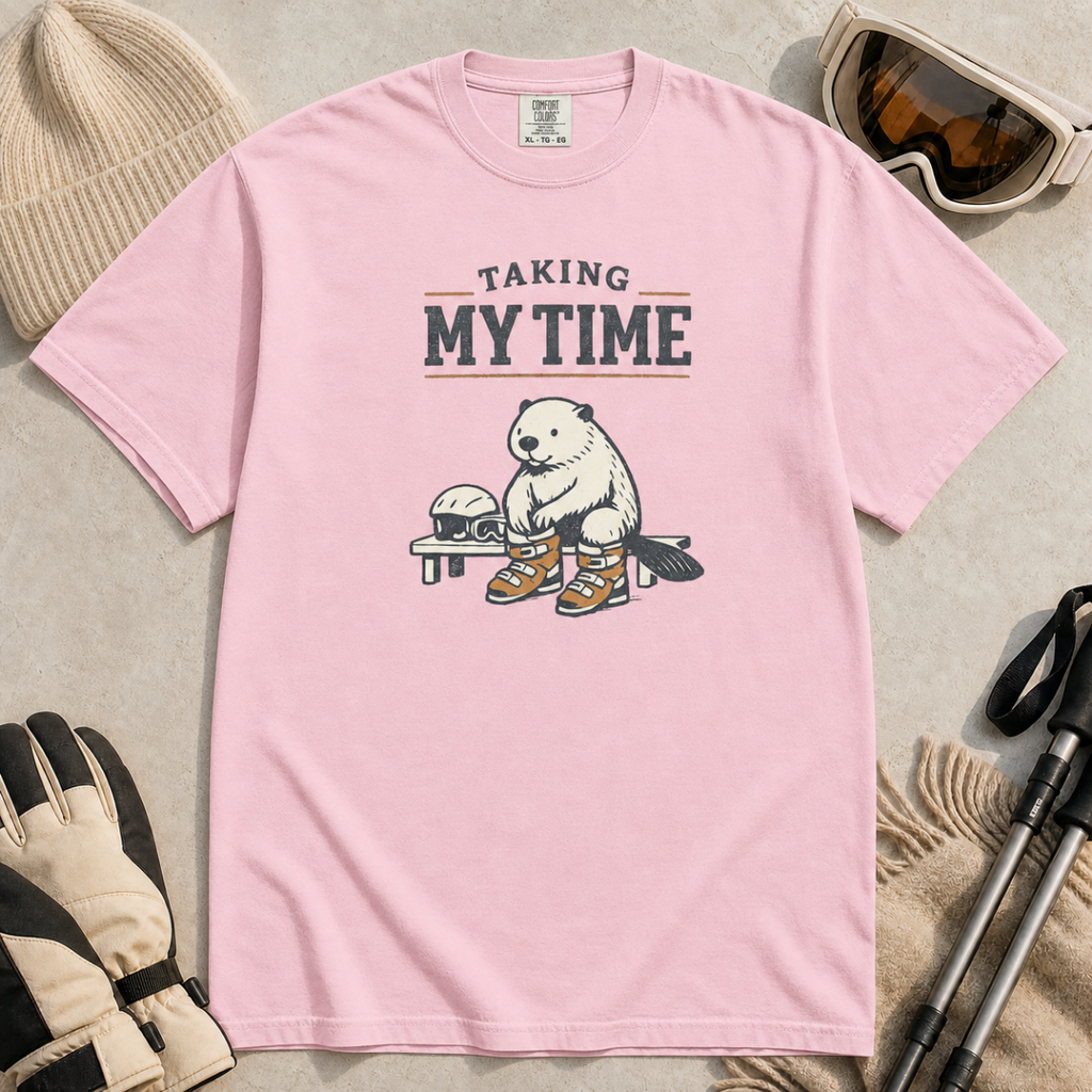 Blossom pink t-shirt featuring a beaver seated on a bench fastening snowboard boots beneath “Taking My Time” text.