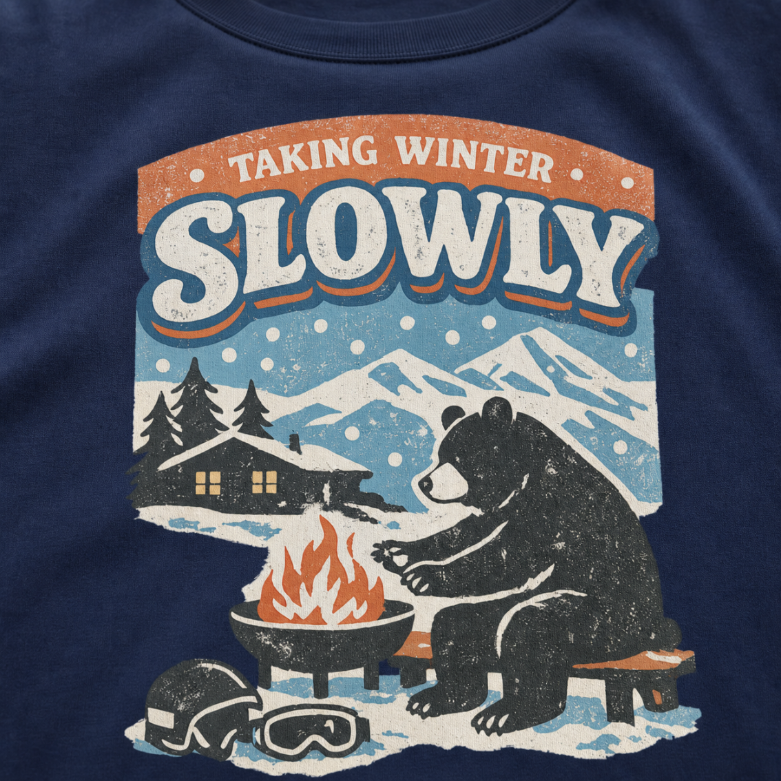 Close-up of a bear sitting beside a winter fire with snowy mountains, a cabin, helmet and goggles.