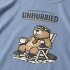 Close-up of a beaver relaxing in a folding chair with a mug, ski goggles and necktie beneath “Professionally Unhurried” text.