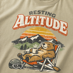 Close-up of a relaxed marmot reclining in a chair with a steaming mug beneath “Resting Altitude” lettering and a mountain sunset.