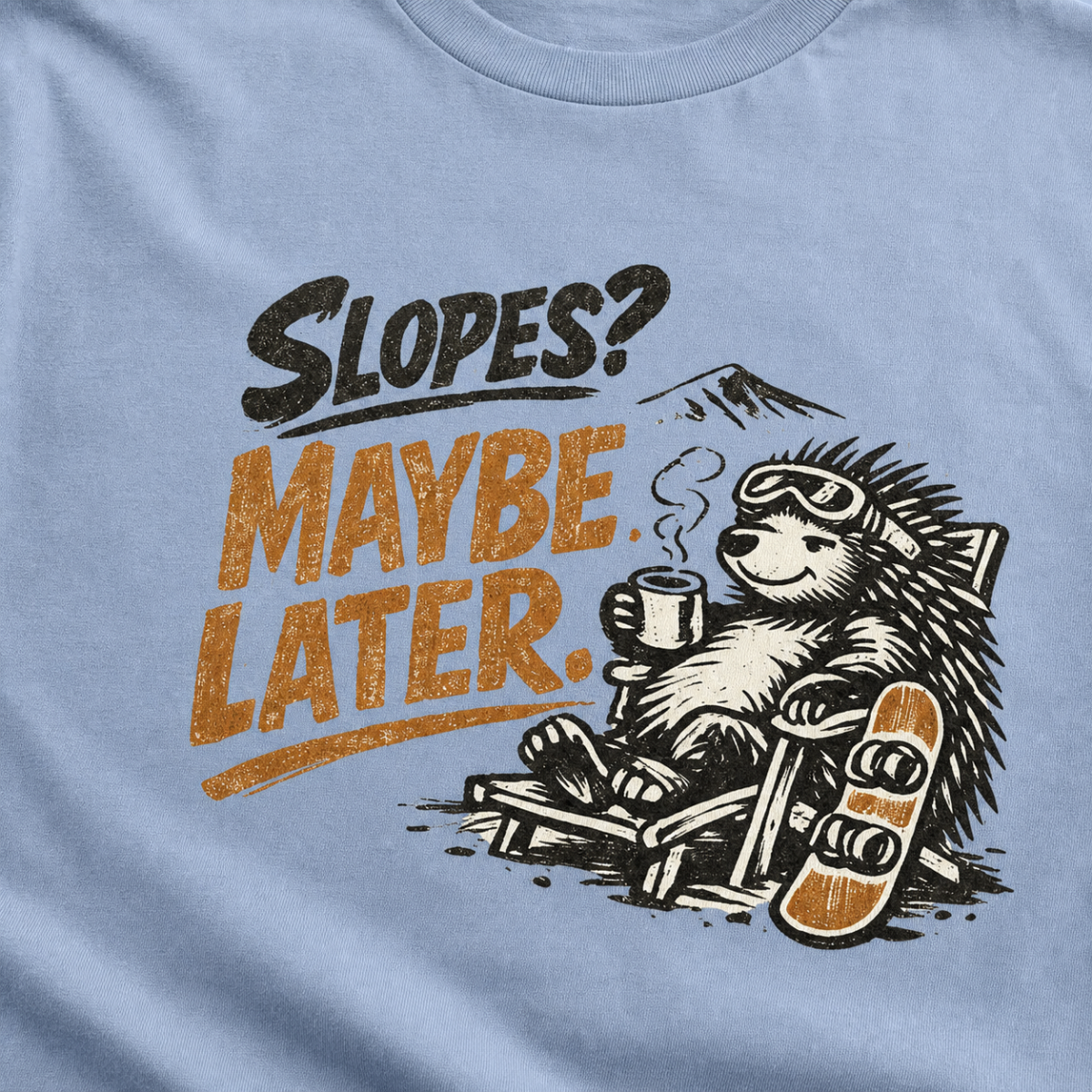 Close-up of a reclining hedgehog holding a hot drink beside a snowboard with “Slopes? Maybe Later.” lettering.