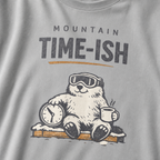 Close-up of a granite gray t-shirt design showing a relaxed marmot with ski goggles, a clock and steaming mug beneath the words “Mountain Time-ish.”
