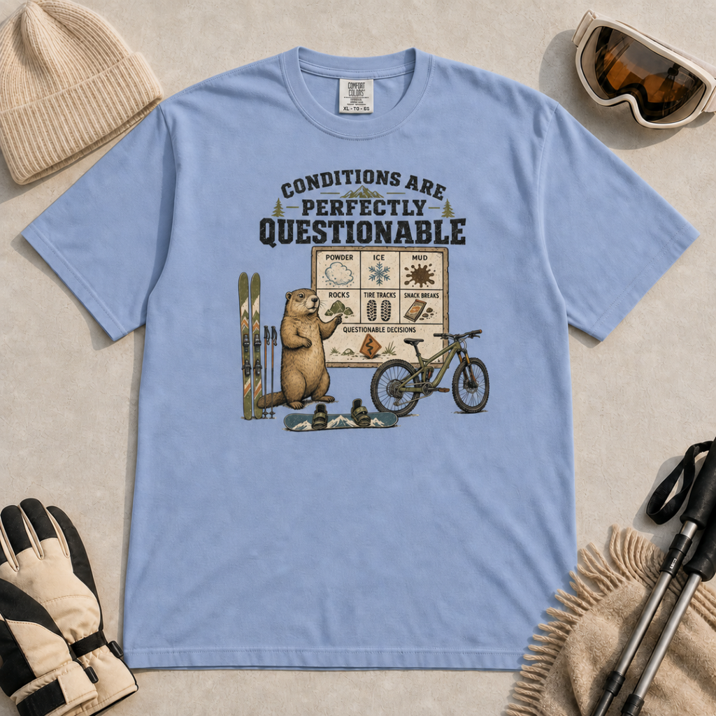 Washed denim blue t-shirt featuring a marmot with skiing, snowboarding, and mountain biking gear under “Conditions Are Perfectly Questionable” text.