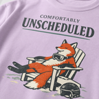 Close-up of a relaxed fox wearing ski goggles in a chair with the words “Comfortably Unscheduled.”