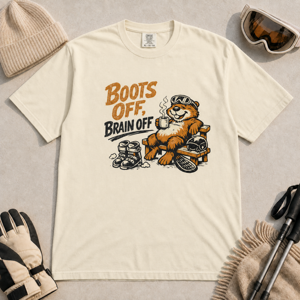 Ivory white t-shirt featuring a marmot relaxing on a bench with ski gear and the words “Boots Off, Brain Off.”