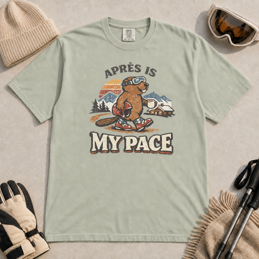 Bay green t-shirt featuring a beaver in ski boots holding a mug beneath the words “Après Is My Pace.”