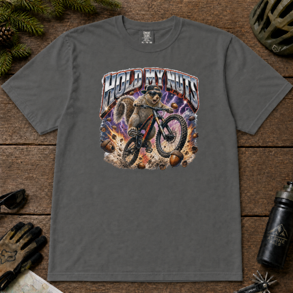 Pepper gray t-shirt featuring a squirrel mountain biking through flying acorns beneath the words “Hold My Nuts.”